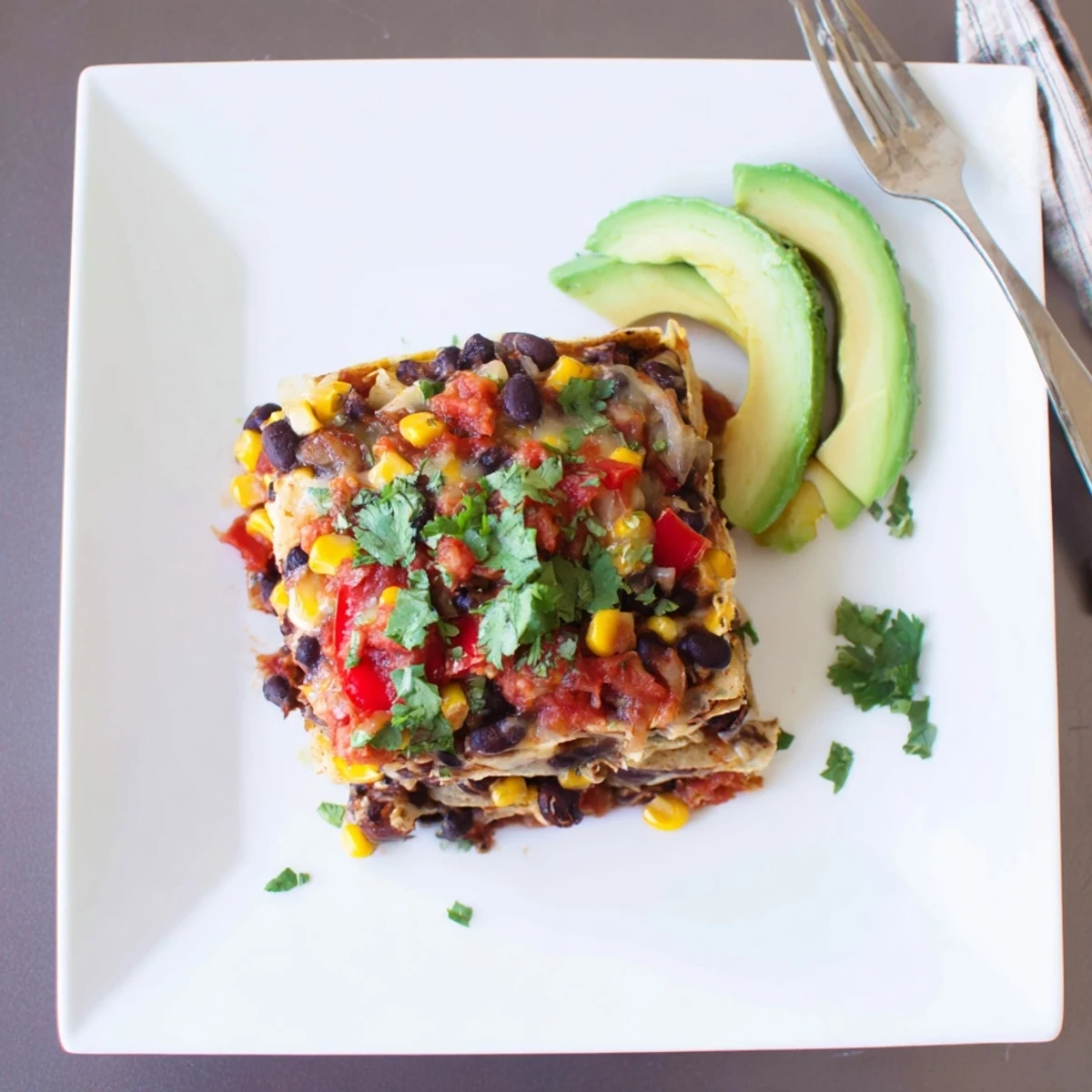 A flavorful layered Quick Black Bean and Corn Tortilla Casserole showcasing golden, bubbly cheese and vibrant ingredients.