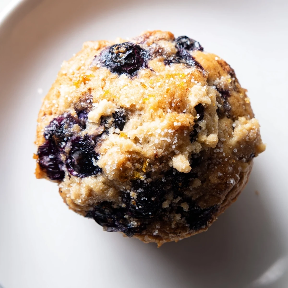 Warm, freshly baked Budget Christmas Blueberry Muffins with juicy berries and a cinnamon sugar topping.