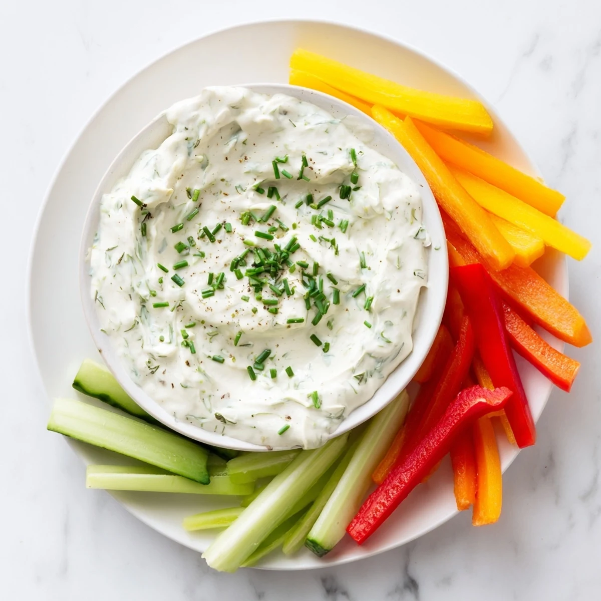 Creamy Kids Dip with ranch, surrounded by colorful, crisp veggie sticks for dipping and snacking.