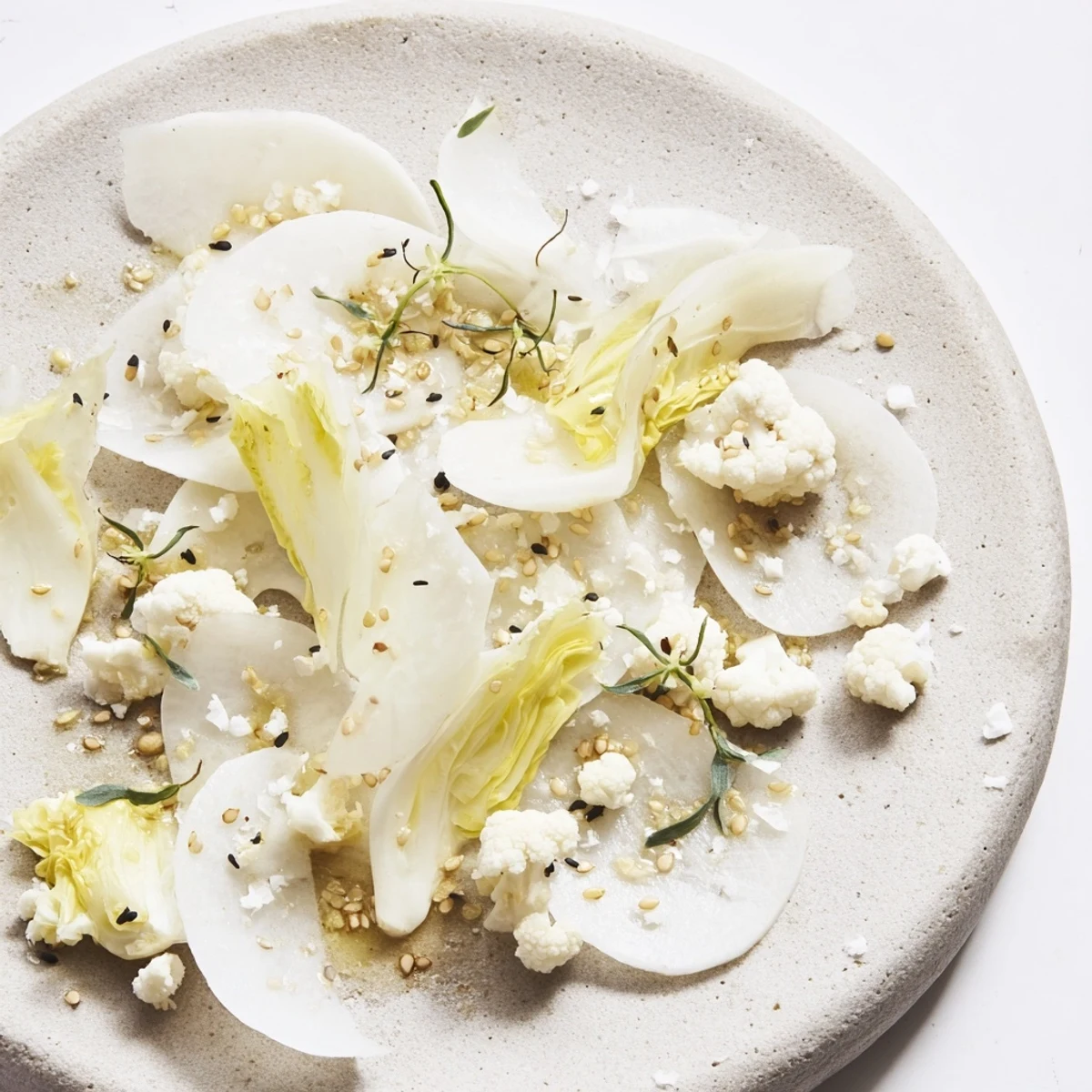 Enjoy a refreshing "Tundra Trek" salad: see the delicate arrangement of pale vegetables and garnishes.