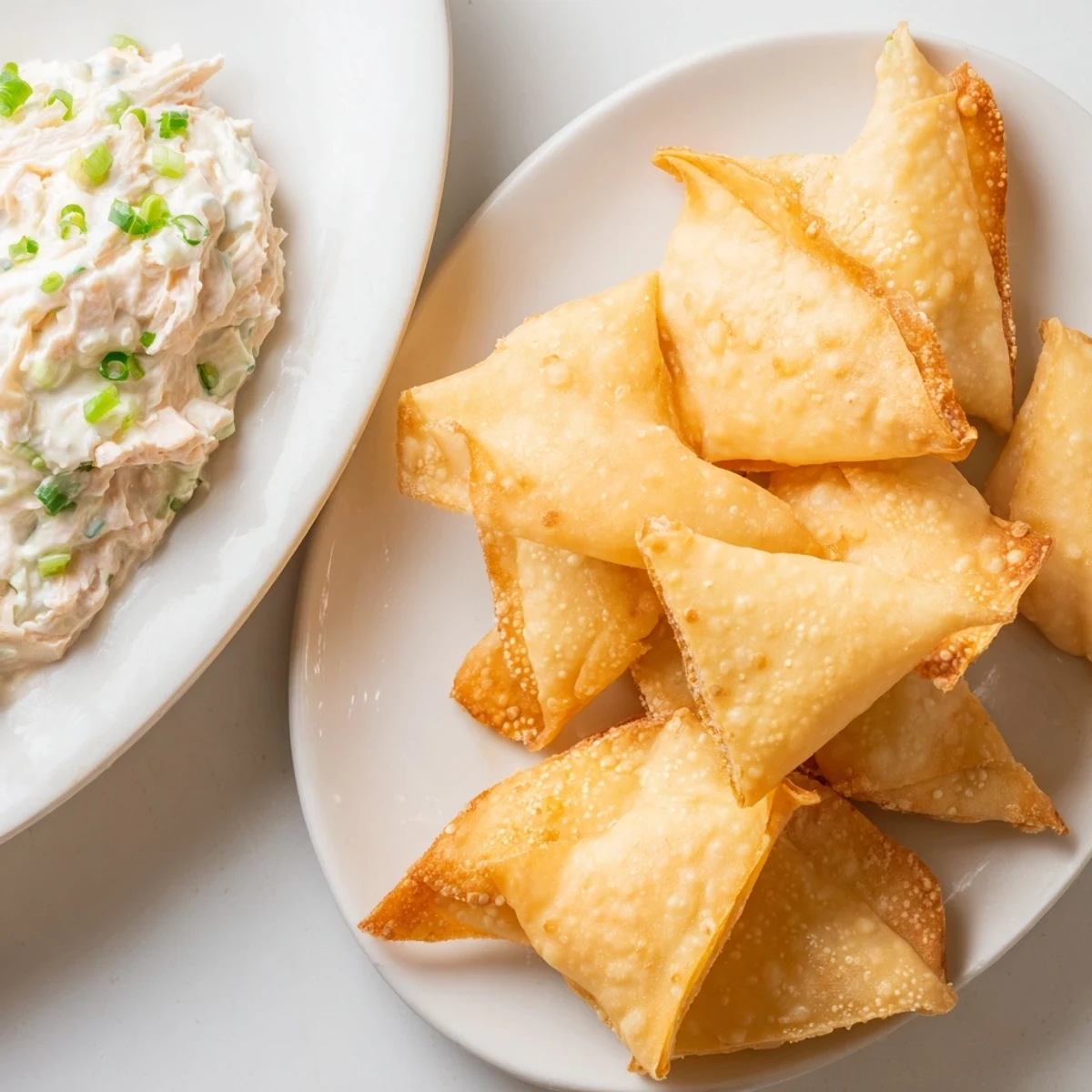 Golden-brown, crispy air fryer lumpia chips alongside creamy chicken cream cheese dip, a delicious appetizer.