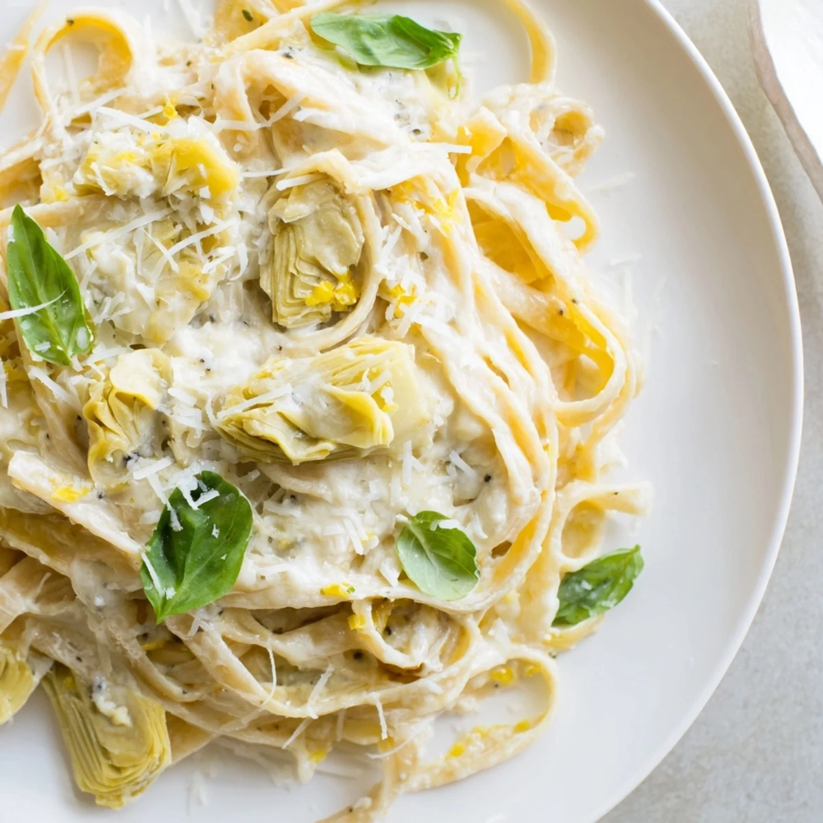 Golden, creamy lemon artichoke pasta with fresh basil, a vibrant Italian dinner bursting with flavor.