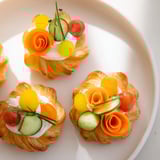 Delicate Fairy Garden Flower Shaped Snacks with bright cherry tomatoes and crunchy cucumber garnish.
