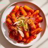 Savory Korean Tteokbokki: Chewy rice cakes swimming in a spicy gochujang sauce, ready to serve.
