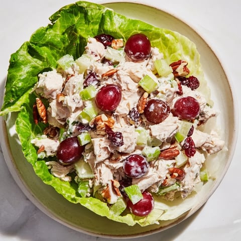 Festive Chicken Salad Cups, filled with grapes and pecans, nestled in crisp lettuce—a delicious appetizer.