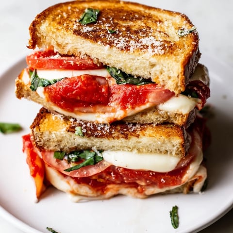 Golden brown Air Fryer Pizza Margherita Grilled Cheese, oozing melted mozzarella and fresh tomato slices.