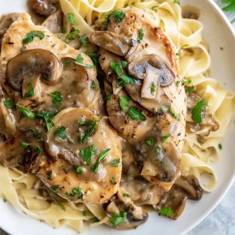 Pan-seared chicken breasts coated in golden, crispy edges, smothered in a creamy Marsala wine and mushroom sauce served over fettuccine.
