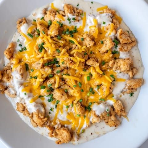 A close-up of a flavorful Cheddar Ranch Chicken Bake, showcasing tender chicken beneath a cheesy layer.