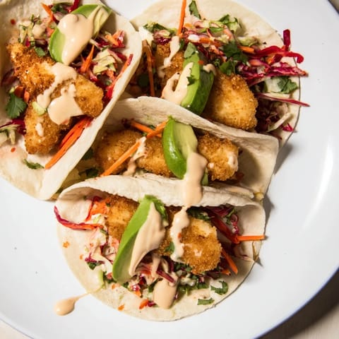 Bright, colorful image of Crispy Fish Tacos showcasing the golden-brown fish fillets and fresh toppings.