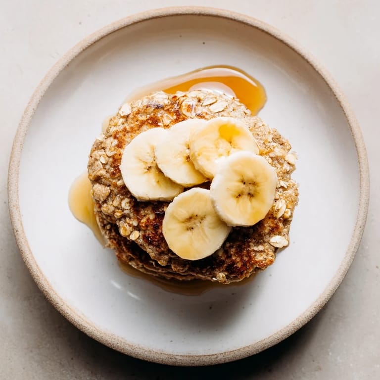 Delicious banana oat pancakes showcasing a warm, inviting stack, ready to be drizzled with syrup.