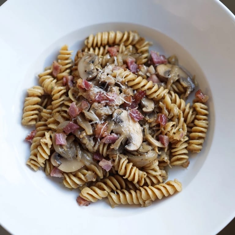 Perfectly cooked fusilli with crispy bacon, sautéed mushrooms, and parmesan cheese for dinner.