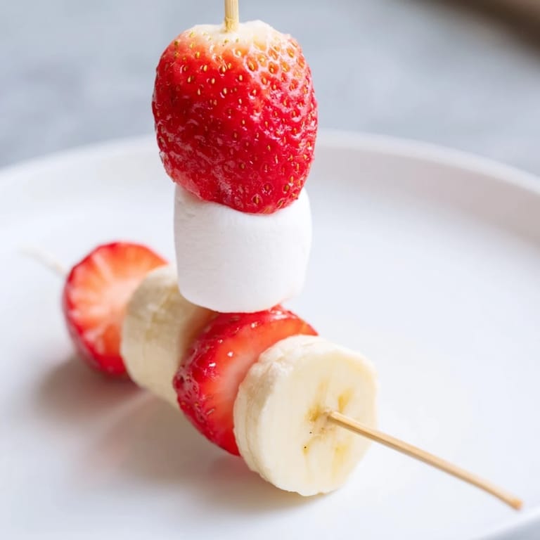 Easy-to-make, colorful Strawberry Banana Santa Sticks, featuring sweet bananas and strawberries, fun to assemble and enjoy.