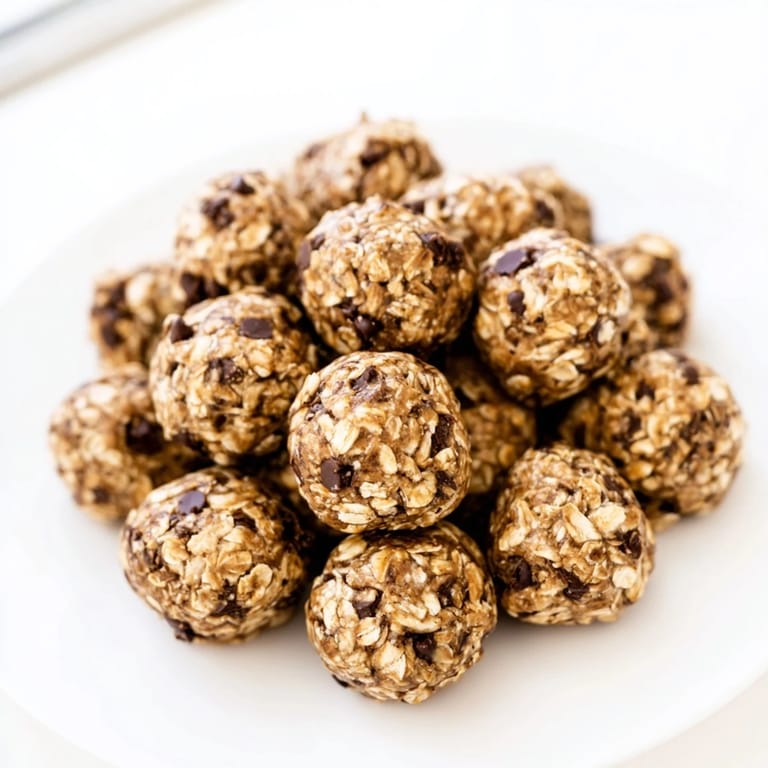 Homemade banana chocolate chip energy balls arranged on parchment paper, featuring a rustic look with chunky chocolate chips and oats.