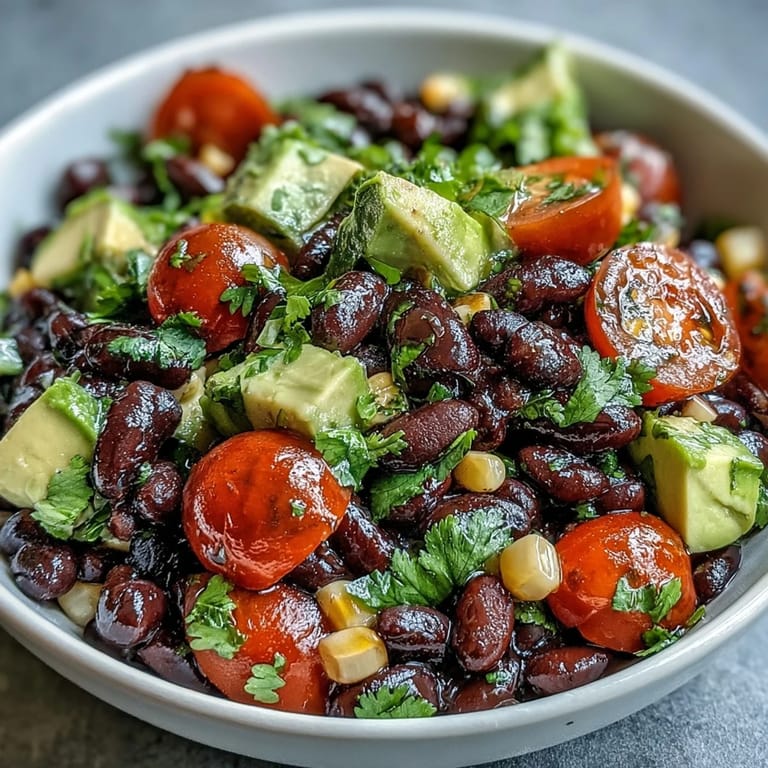Fresh cilantro and pumpkin seeds top a colorful Black Bean and Veggie Bowl, ready to be enjoyed with a zesty lime dressing.